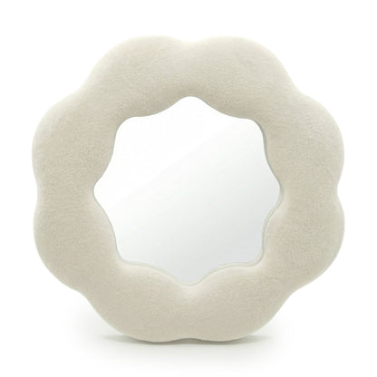 Round, beige cushion with a textured surface on a white background