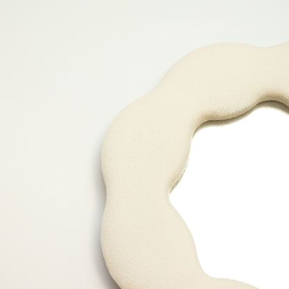 Beige fabric with a wavy texture on a light gray background