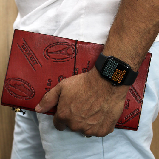 Person holding a red leather wallet with a digital watch on wrist